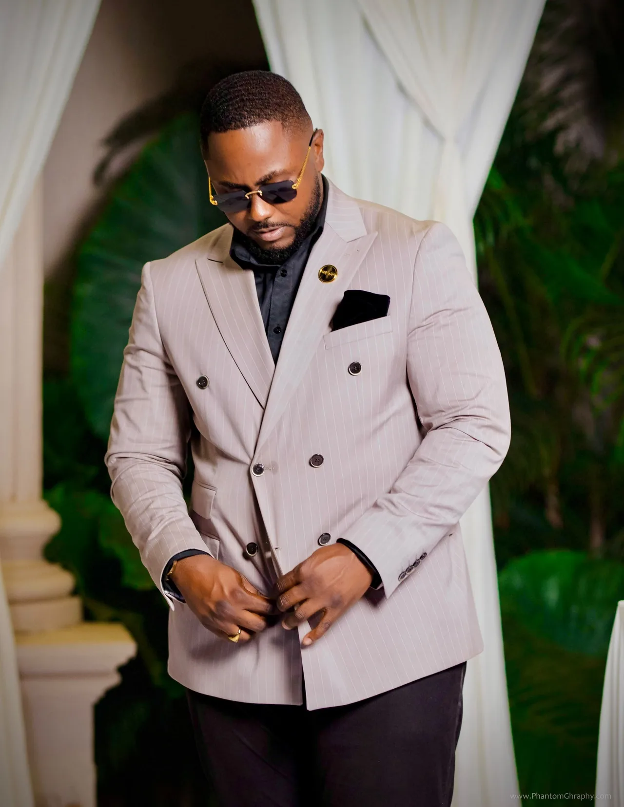 Edwin Elikem Amenyeawu fastening a pinstripe jacket
